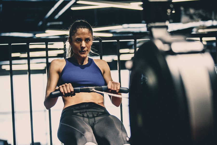 woman using rowing machine for benefits of cardio and strength workout